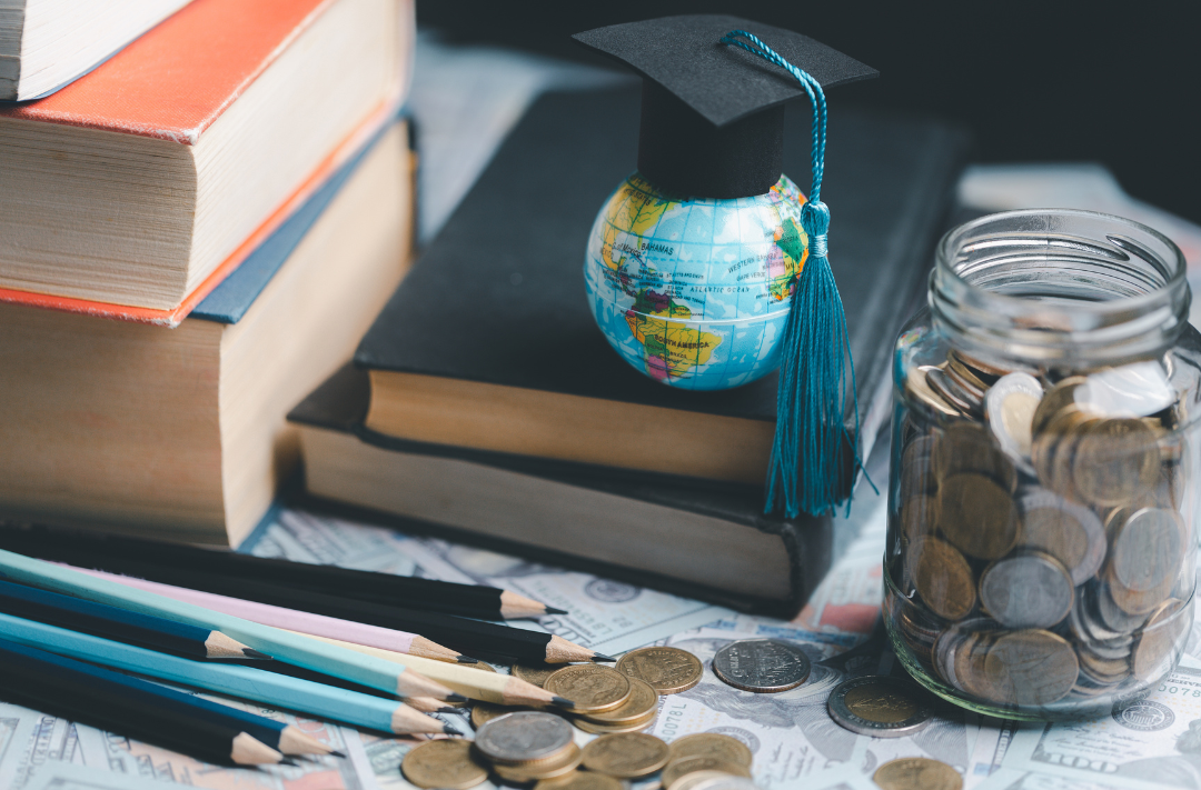Earth globe with graduation hat sitting on books