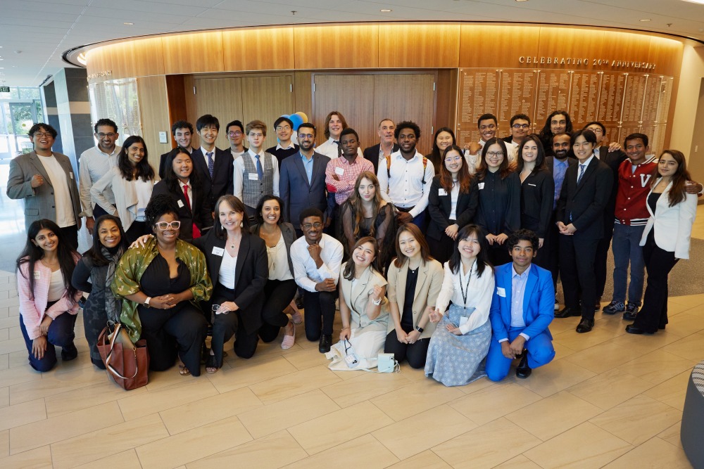 An assortment of students participating in the Impactathon pose for a photo outside of a classroom in Curie Hall.