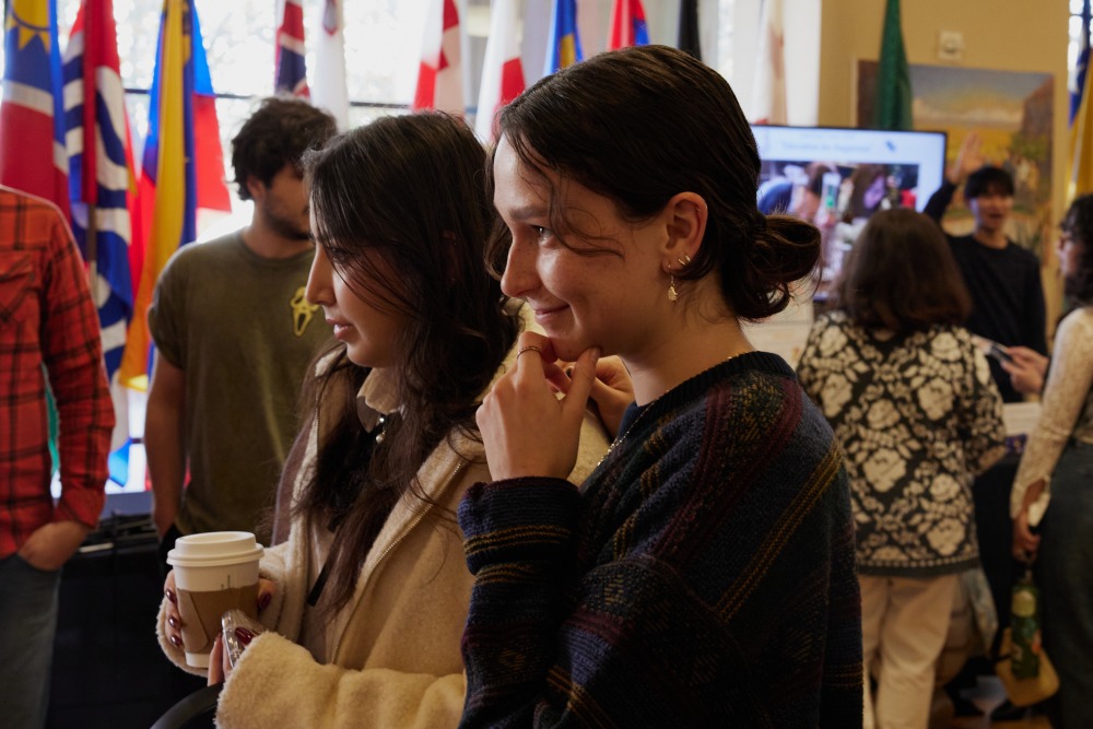 Two students smile as they browse the Learning Cluster Fair