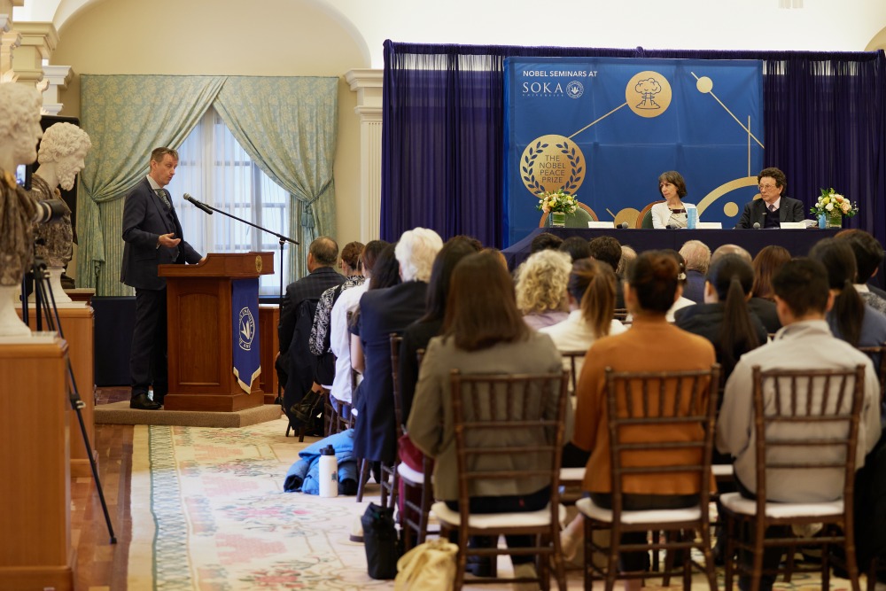 Dr. Asle Toje speaks at the podium while Dr. Ivana Nikolić Hughes, Dr. William Potter, and the audience listen during the Nobel Seminars