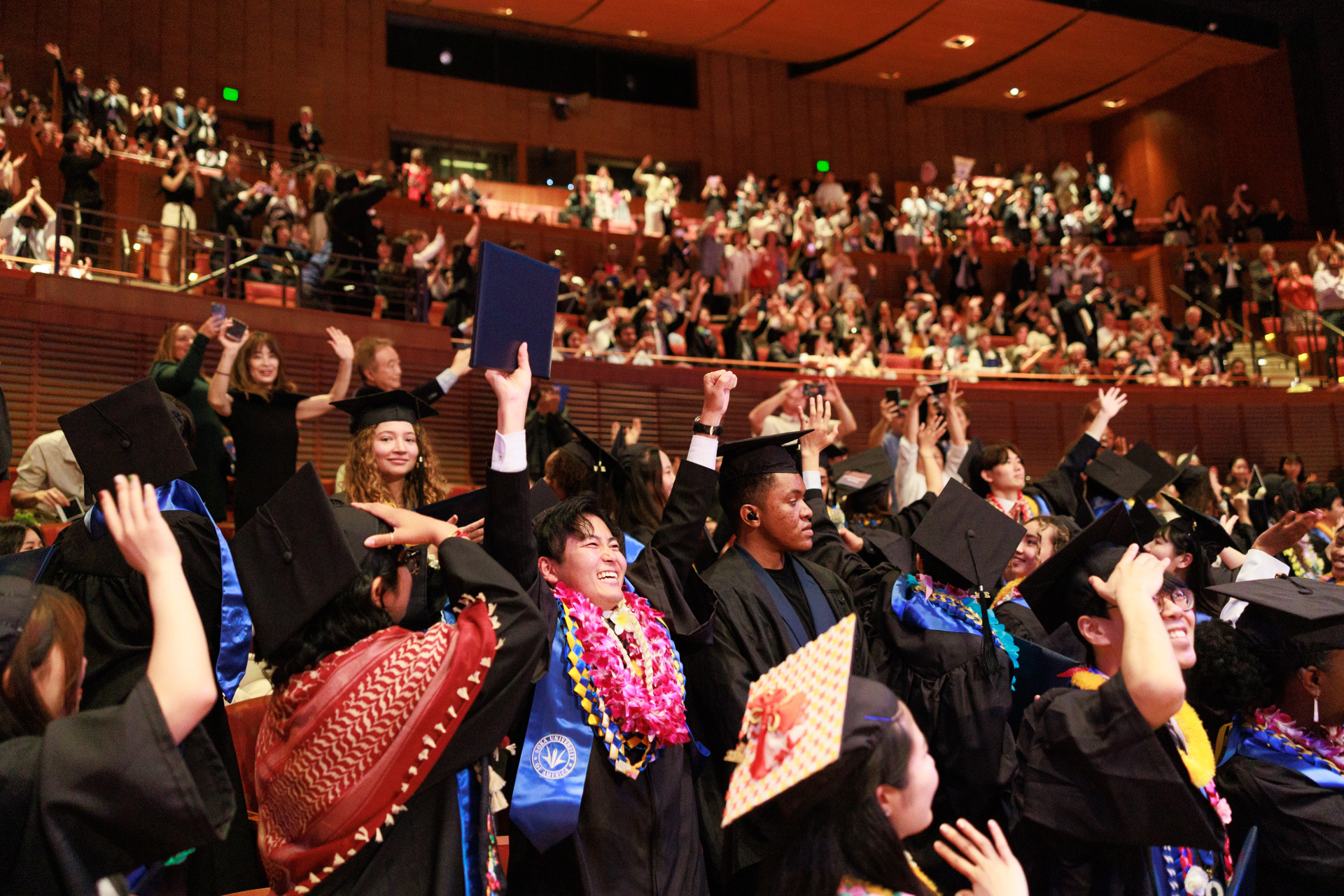 SUA graduates raise their arms in celebration during the 2024 Commencement Ceremony
