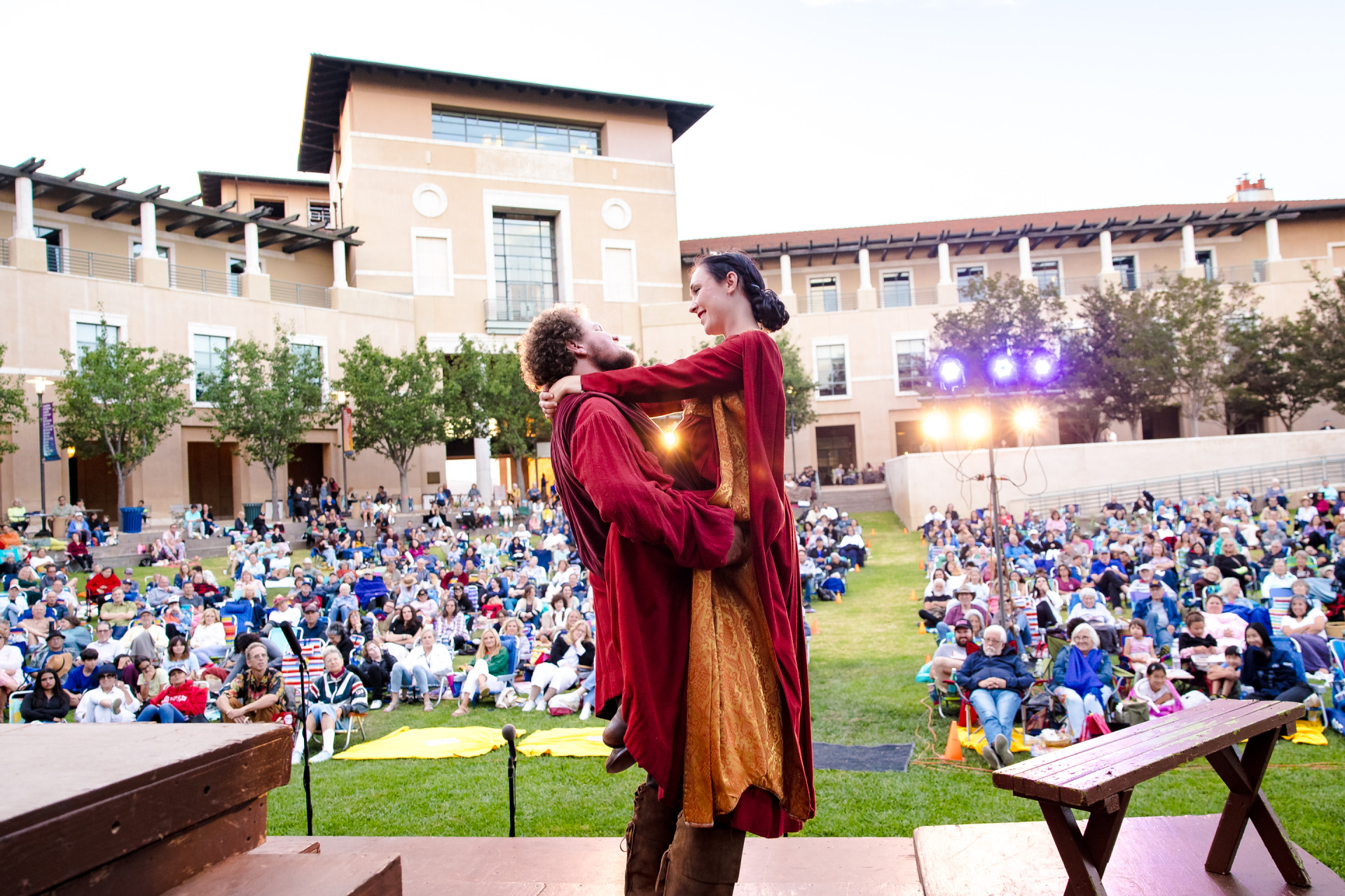 Actors hold eachother during a performance of Shakespeare by the Sea on SUA's Campus Green