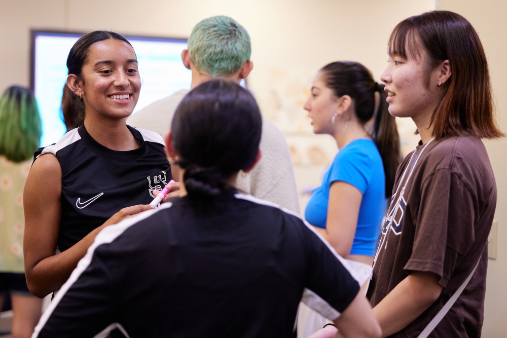 Students mingle in small groups during orientation