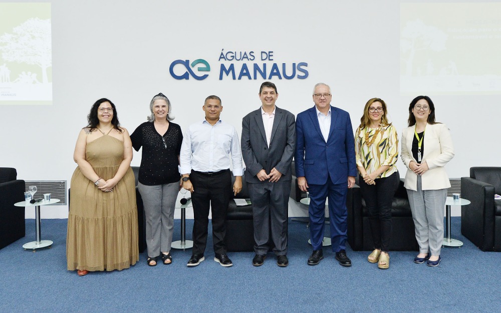 Ed Feasel poses with a group of people to celebrate the new partnership with the Soka Amazon Institute