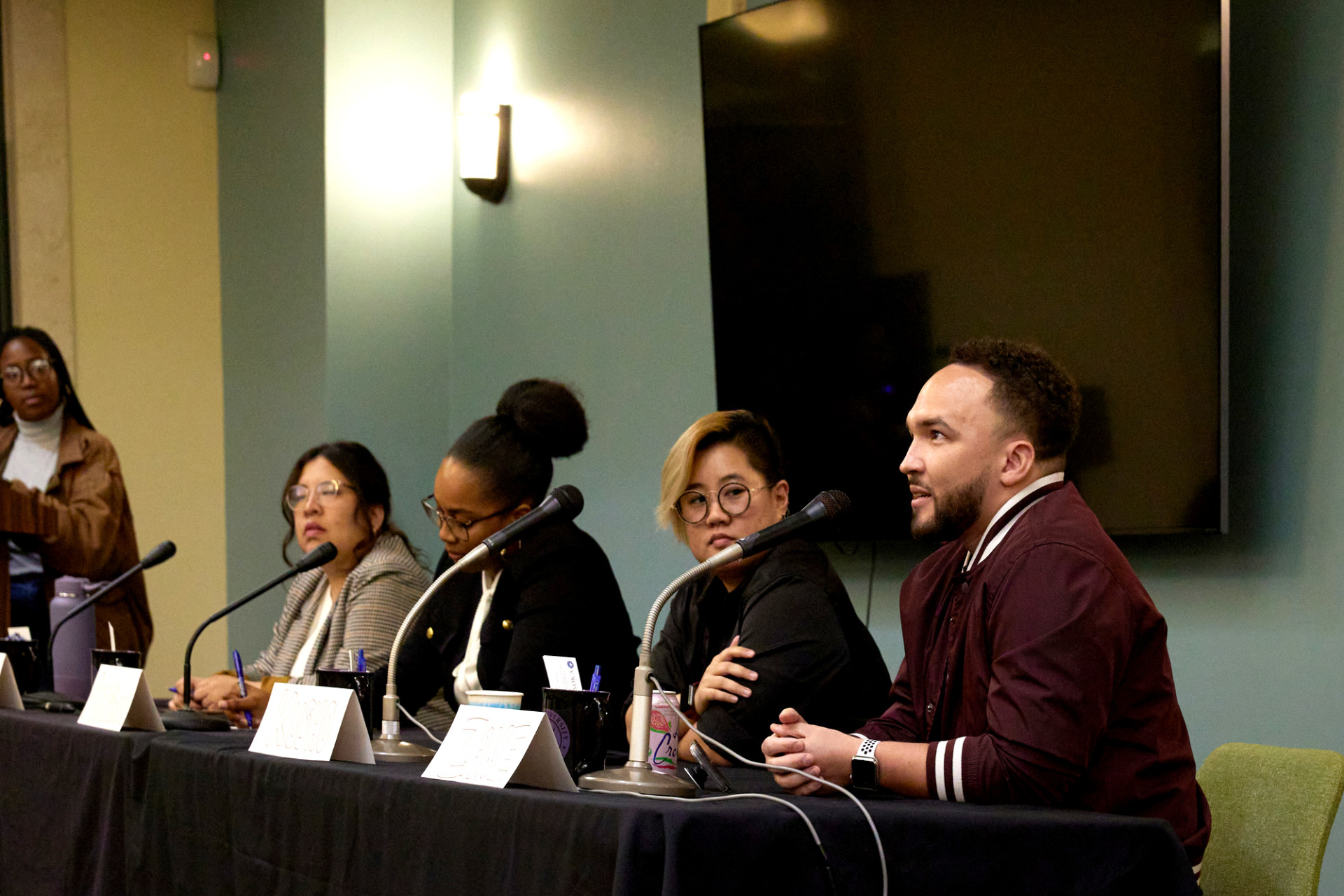 SUA alumni sit at a table with microphones to answer questions during a Career Night event