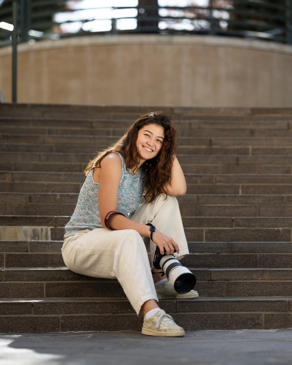 Marina Inoue poses with a camera on SUA's campus
