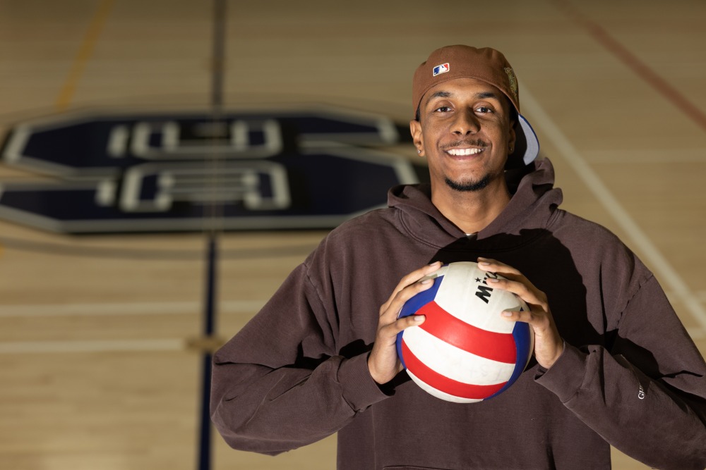 Lucas Ferreira holds a volleyball in SUA's recreation center.