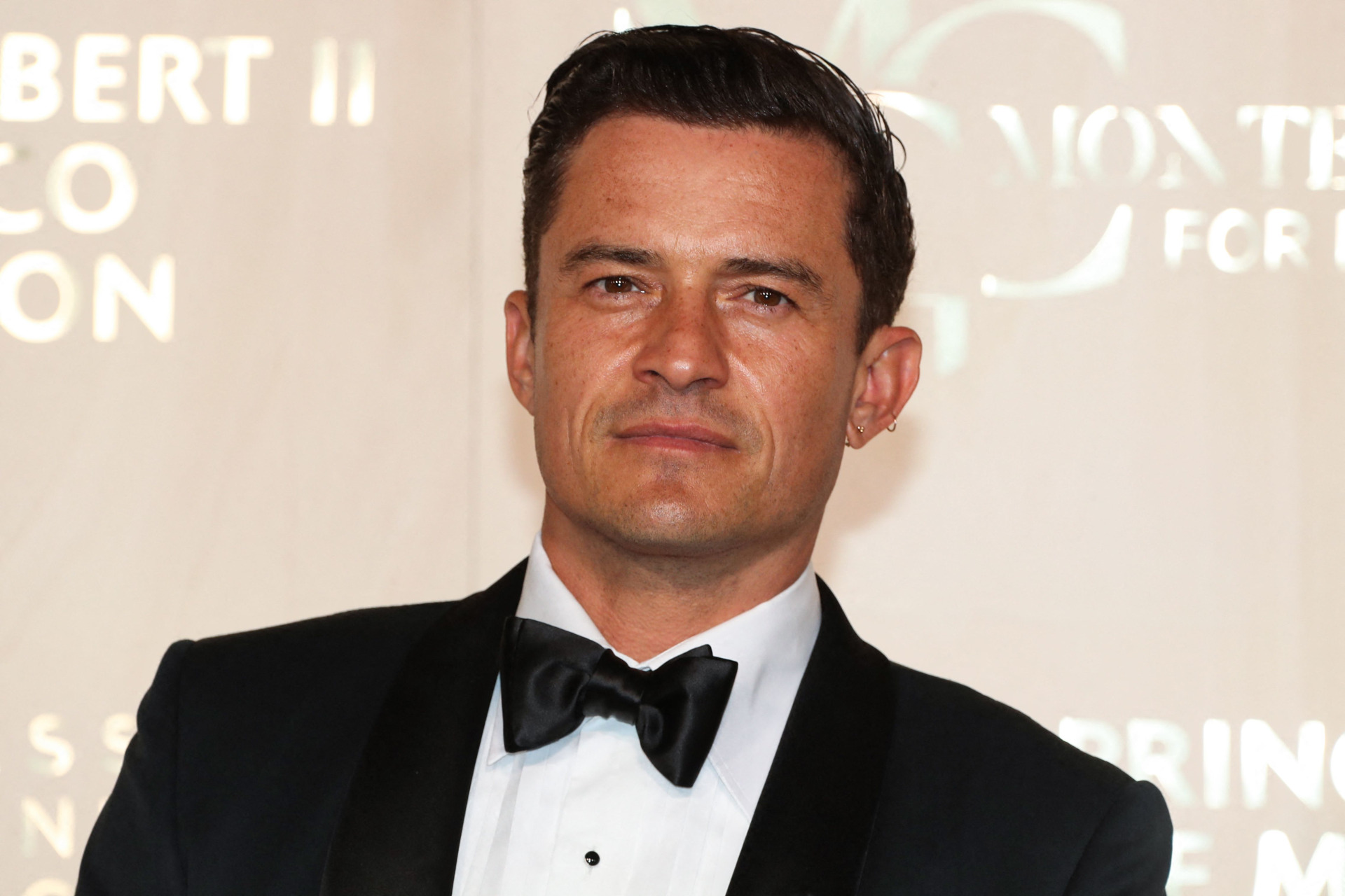 Orlando Bloom poses in a tuxedo at an event. Photo by Valery Hache/AFP via Getty Images