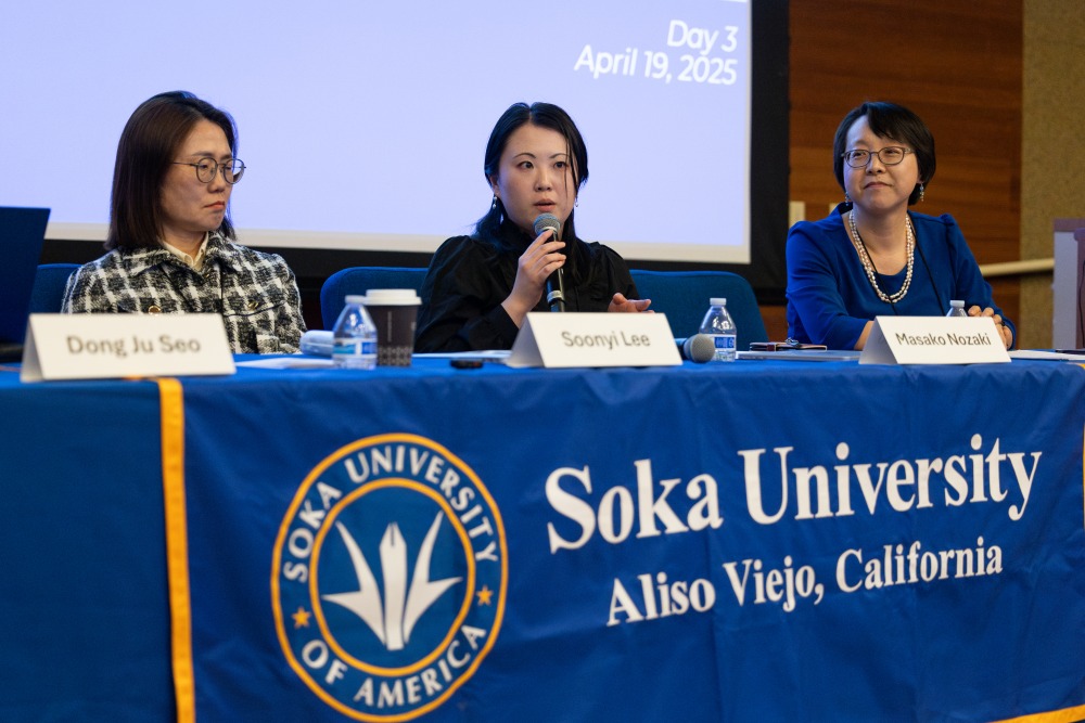 Masako Nozaki speaks into the microphone during a SIGS conference.