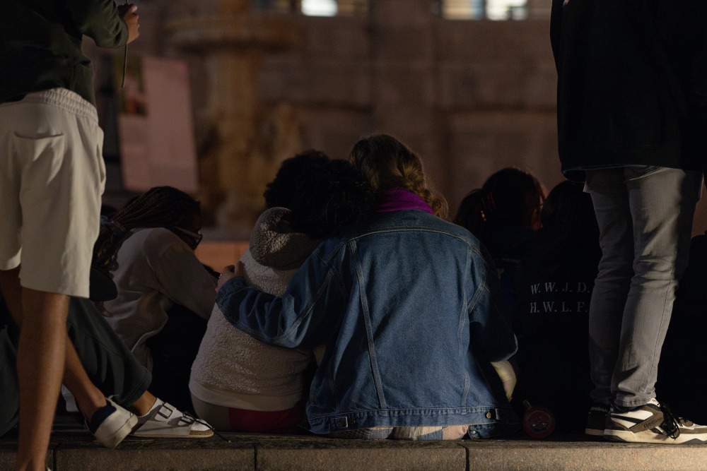 Students sit with their arms around eachother and offer comfort to one another during Lucas' vigil.