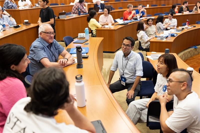 A group of people sitting in an auditorium participate in a discussion.