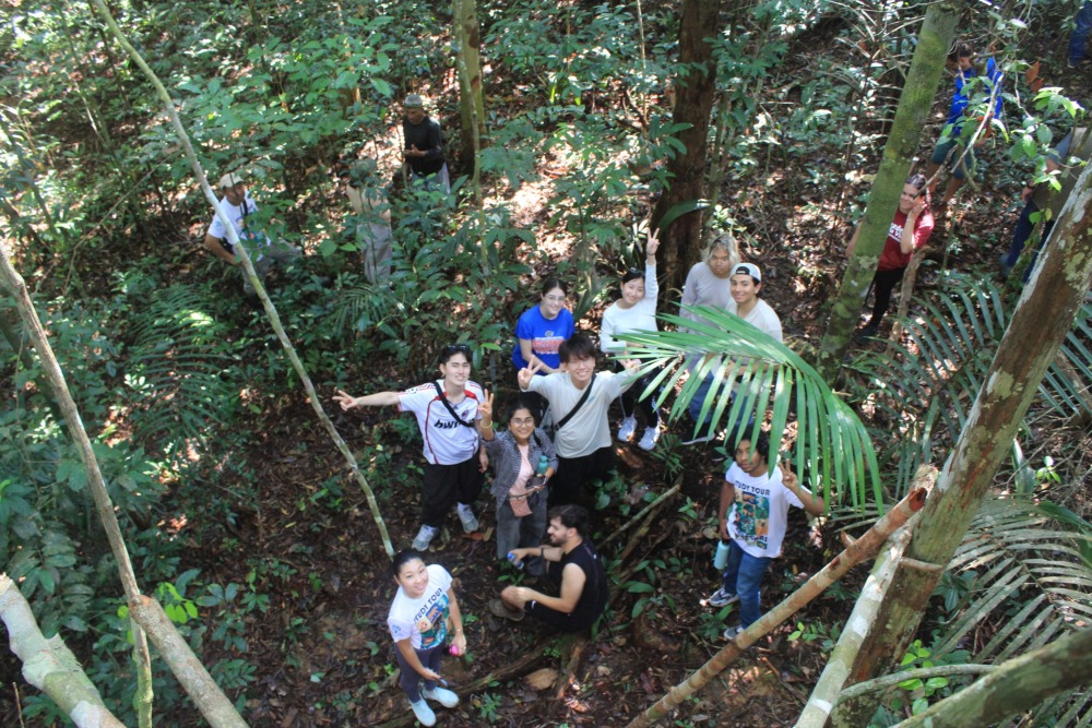 Students pose for an aerial photo taken during a walk through the rainforest.