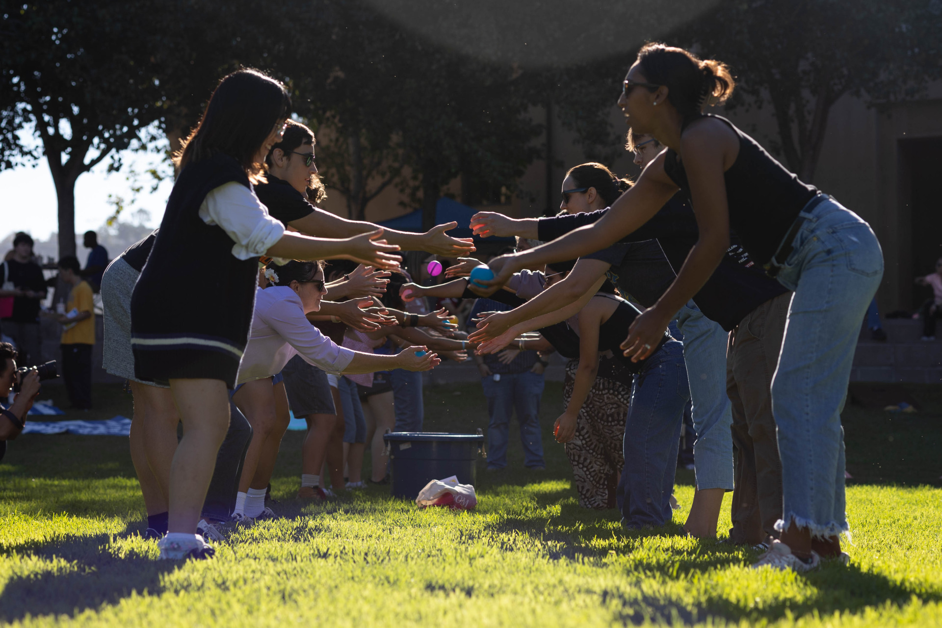 Two lines of people participate in a water-balloon toss during the Welcome Back event on SUA's campus.