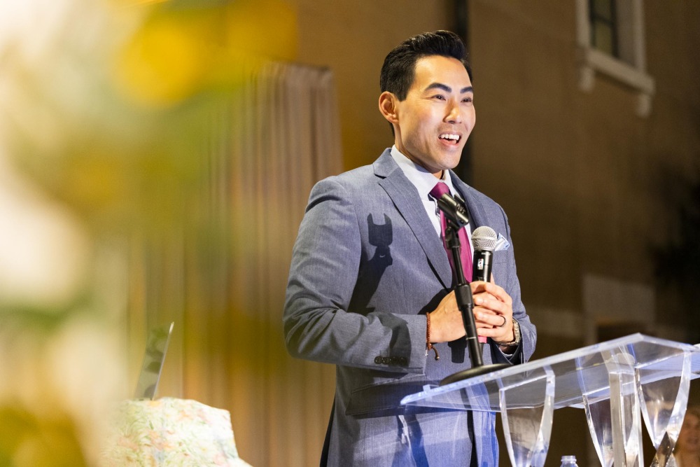 Master of ceremonies, Gene Kang, speaks into the microphone during the gala.
