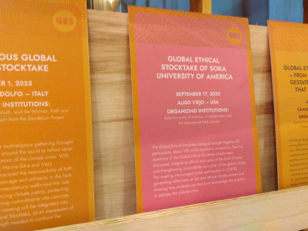 Orange and pink panels with Soka's Global Ethical Stocktake dialogue are displayed during the conference.