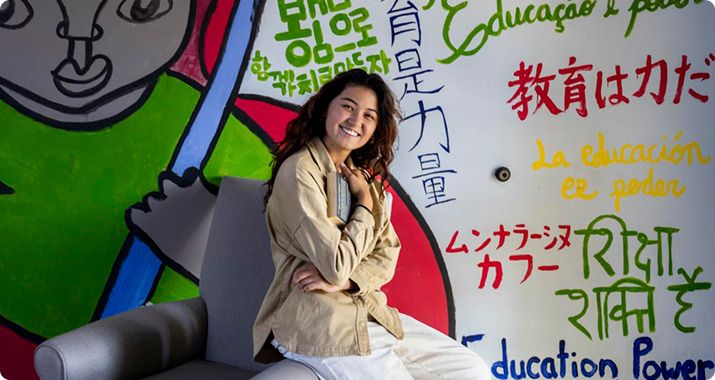 Student leaning against an arm chair