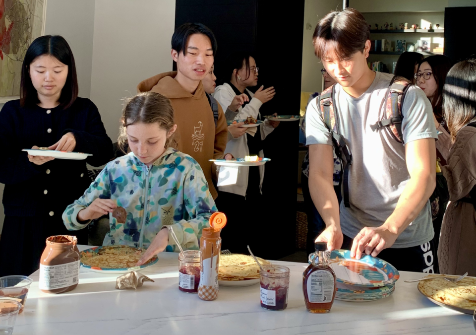 People are preparing plates of crepes