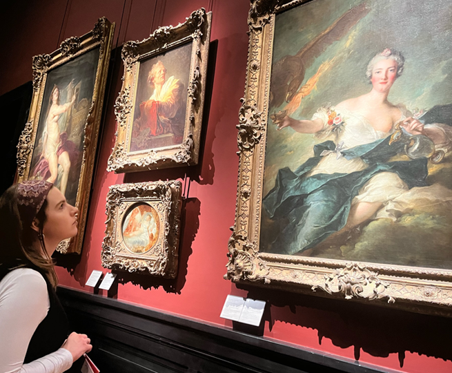 A girl looks at a painting in an art museum