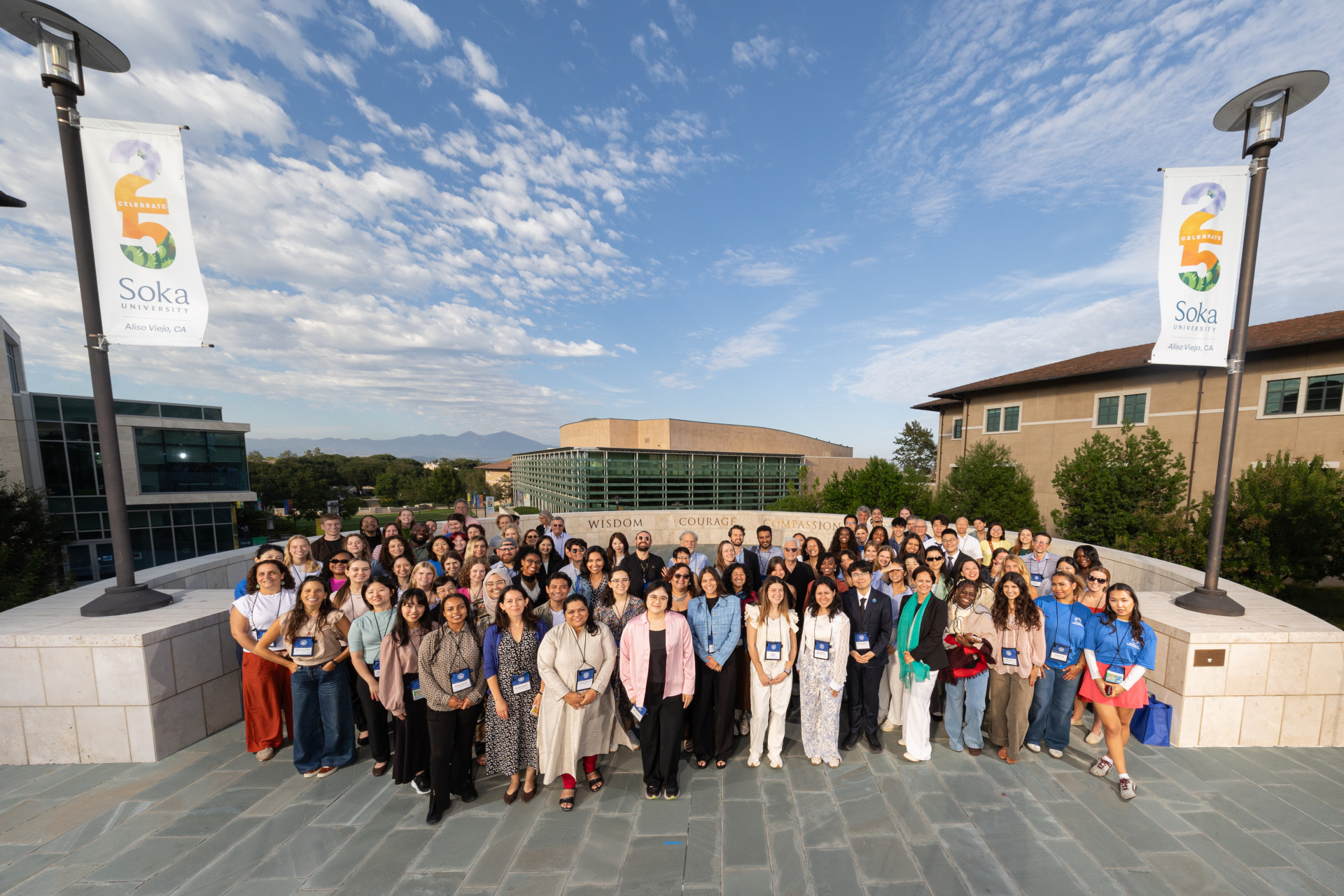 Aerial group photo of conference participants outside on the overlook of SUA's campus.