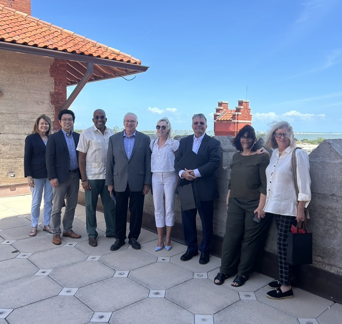 Men and women representing Soka University of America and the Hazel Henderson Center pose for a photo on a rooftop.