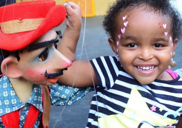 Smiling child playing with marionette