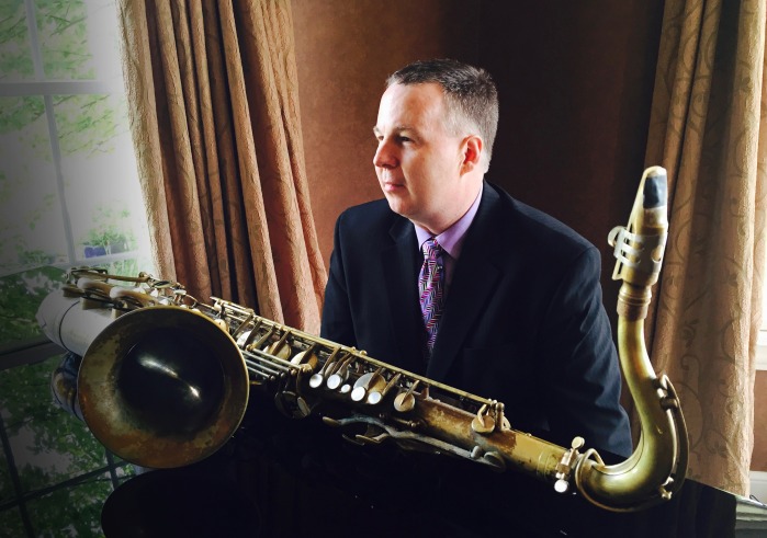 Harry Allen sitting an piano with saxophone