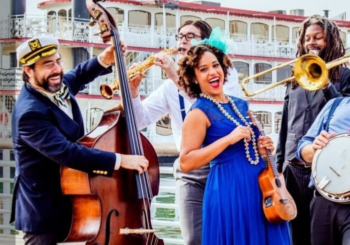 Jazzy Ash and band members playing instruments on a dock