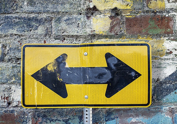 Yellow and black sign pointing in two directions