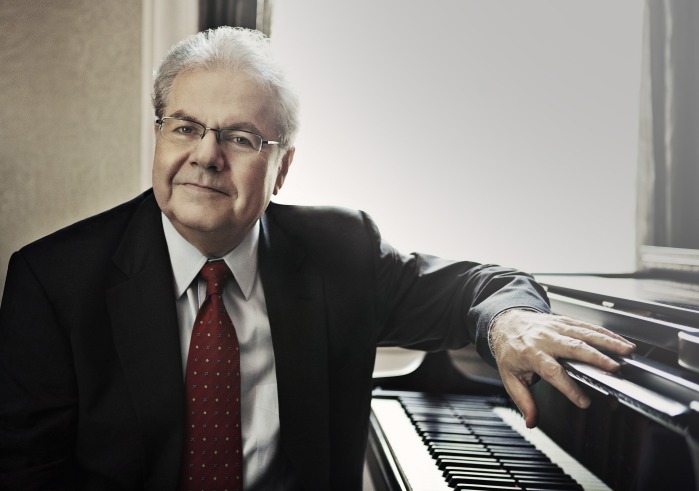 Emanuel Ax, a man dressed in black suit sitting at piano facing camera