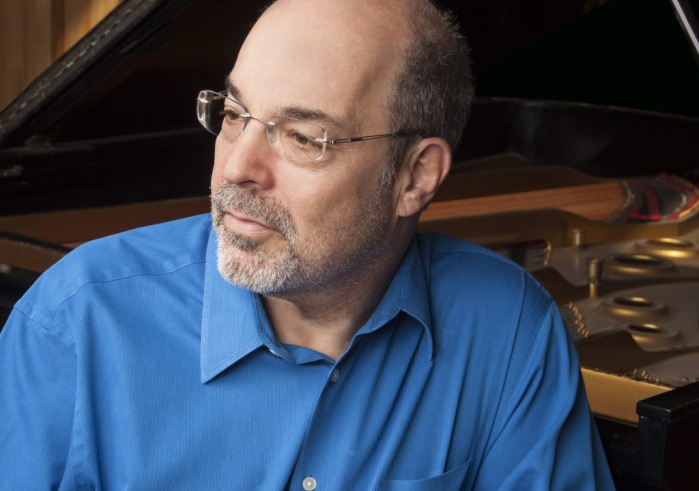 Man in blues shirt sitting at piano