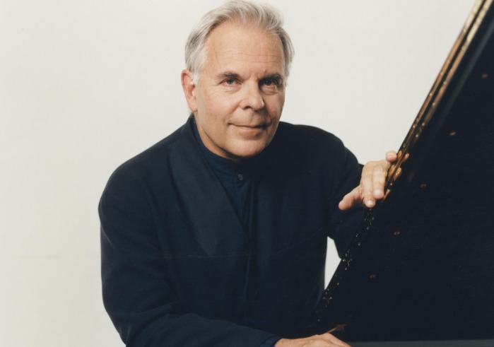 Man in black suit sitting at piano