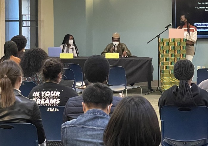 A crowd listens to panelists engaged in discussion during the Black history month event in the Student Affairs lobby