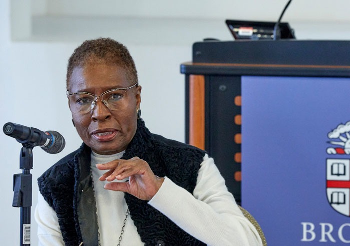 Professor Hortense J. Spillers gestures with her hand as she speaks into a microphone