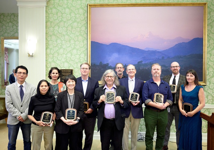 11 Faculty Members pose with their Merit Awards