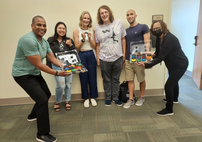 Jonathan Wray and Alisa Proctor present cupcakes to fourth-year students Mercedes Corrales, Kennah Watts, Skyler Wolf, and Leo Salvatore as congratulations for finishing their capstone projects.