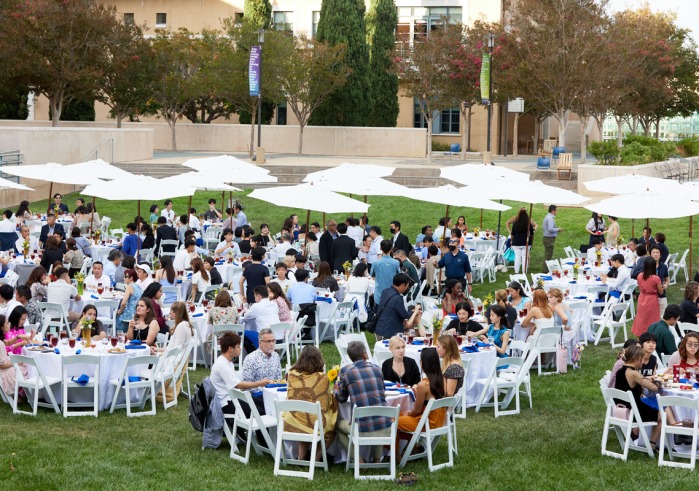 The Class of 2026 sit at circular white tables on the Campus Green during the Welcome Reception