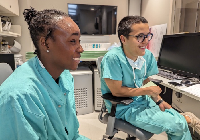 Two students wearing teal scrubs review imaging during their neurosurgery preceptorship in Summer 2023.