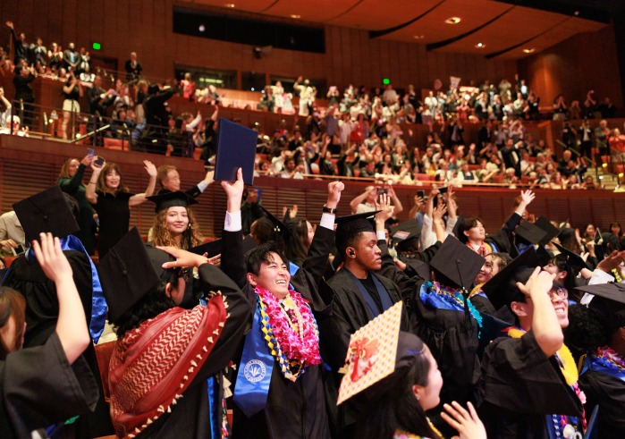 SUA graduates raise their arms in celebration during the 2024 Commencement Ceremony