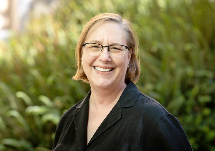 Headshot of Lisa MacLeod in front of greenery