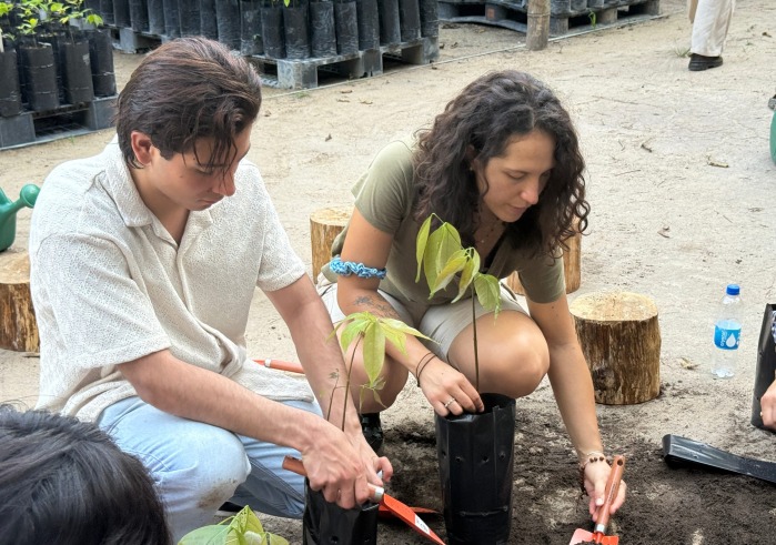 Two students dig with shovels during a native plant species workshop.