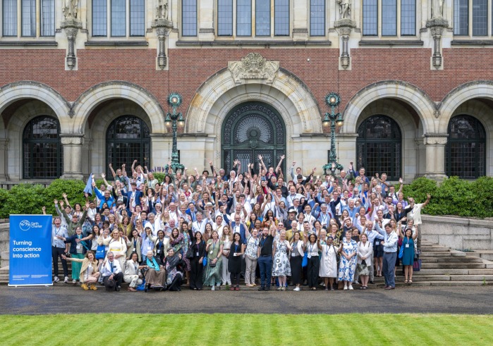340 participants raise their arms and pose for a group photo during the 25th anniversary of Earth Charter event.