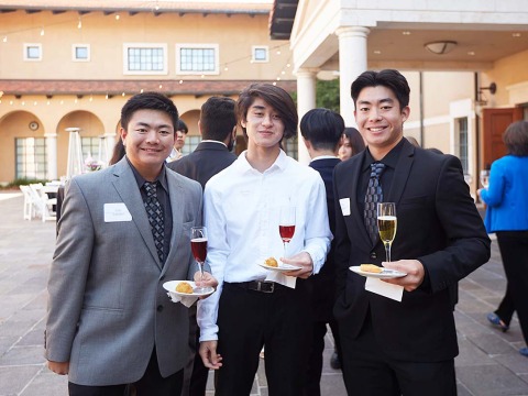 Soka students holding plate and wine glass during networking practice 