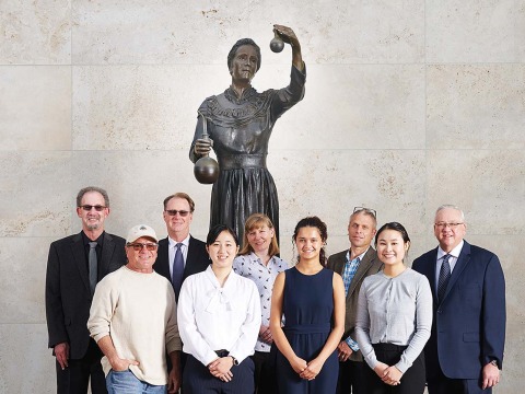 Dignitaries in front of the Marie Curie statue at Curie Hall