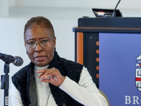 Professor Hortense J. Spillers gestures with her hand as she speaks into a microphone