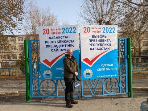 Dr. Shane Barter poses in front of an election sign in Kazakhstan.