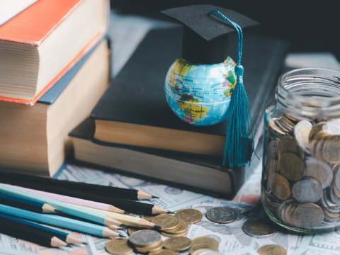 Earth globe with graduation hat sitting on books