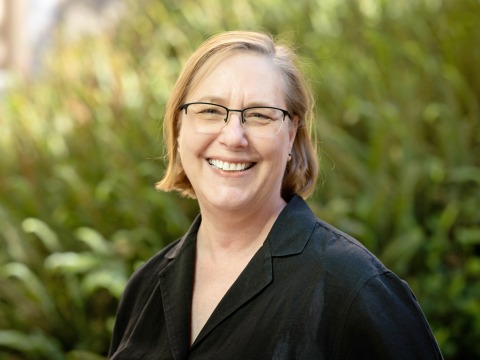 Headshot of Lisa MacLeod in front of greenery