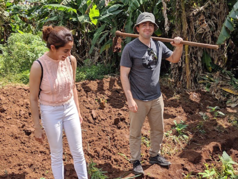 Nandini Puri ’14 stands with her husband and business partner, Andrew Bawdon on farmed soil.