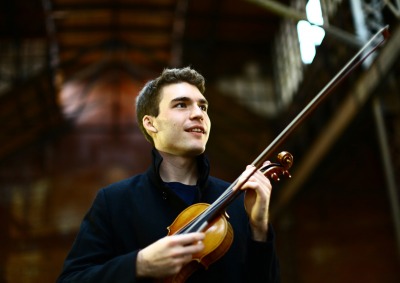 Alexi Kenney holding violin