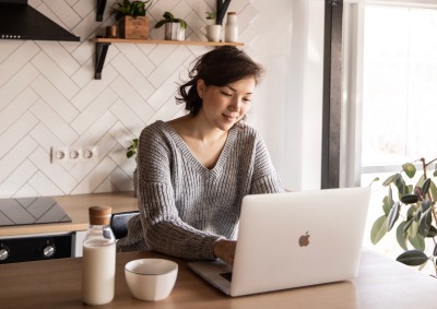 Girl Using Laptop in Kitchen